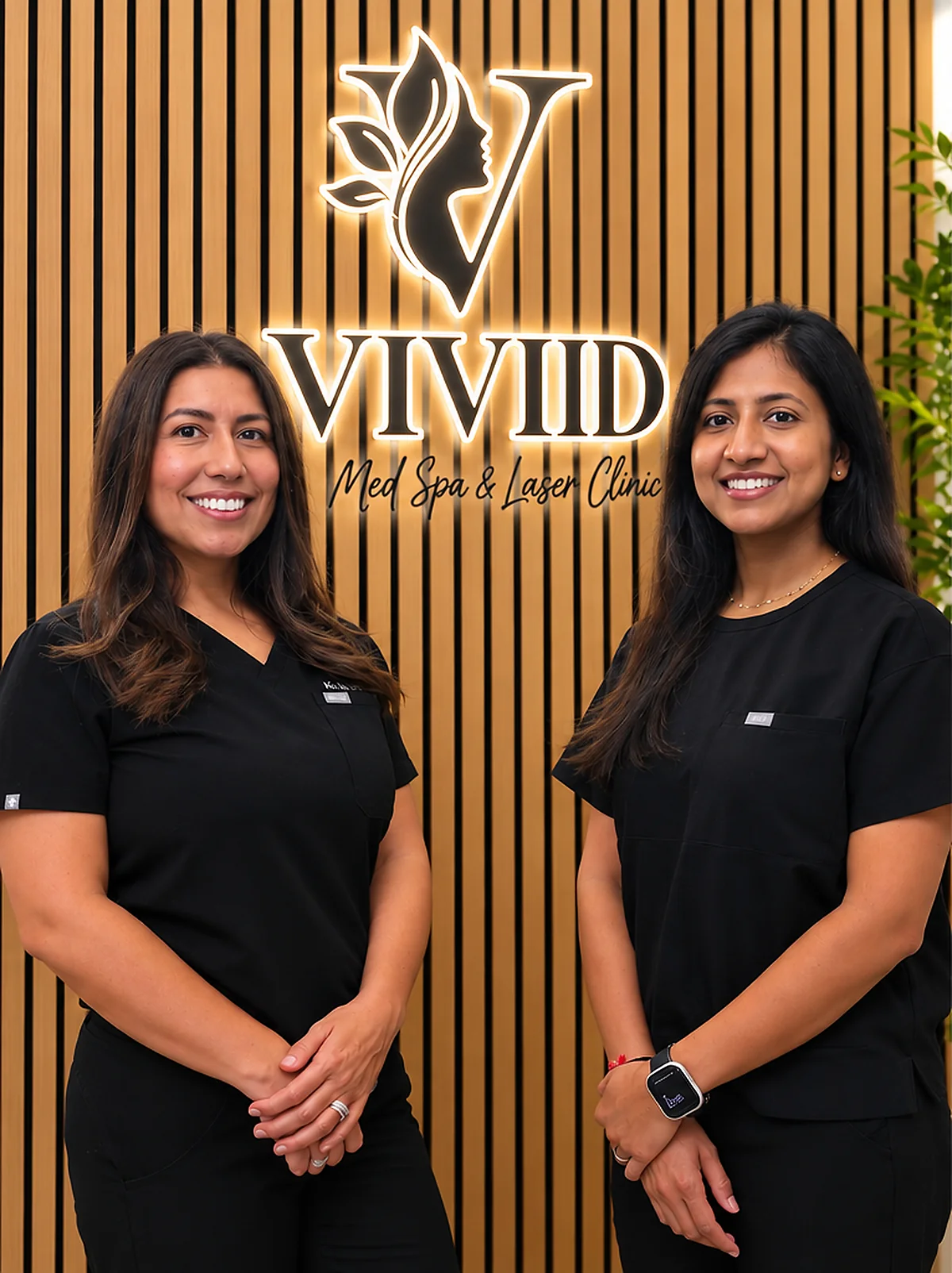 Kia Brooks, RN and Ria Jivan, BSN, RN in front of the glowing VIVID sign